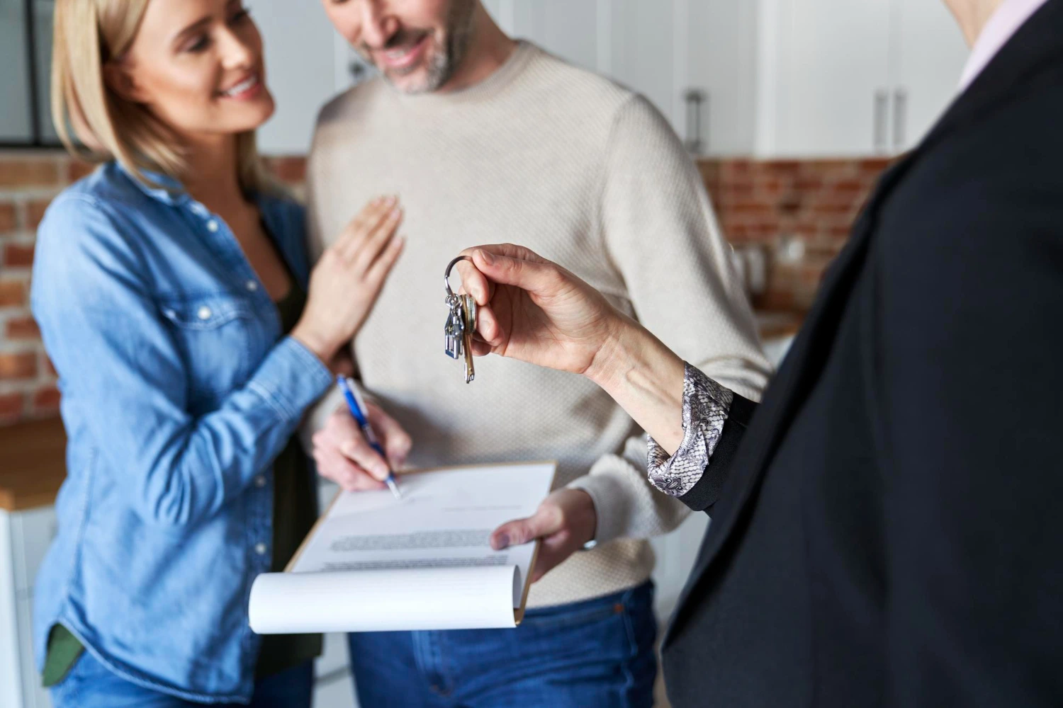 Pareja feliz firmando los documentos para separar su vivienda nueva en Colombia